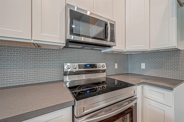 kitchen featuring decorative backsplash, white cabinetry, and appliances with stainless steel finishes