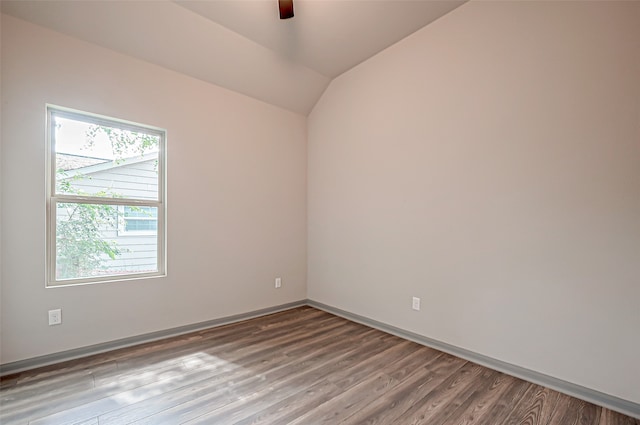 unfurnished room with ceiling fan, vaulted ceiling, and hardwood / wood-style floors