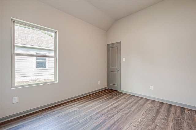 unfurnished room with vaulted ceiling and light hardwood / wood-style flooring