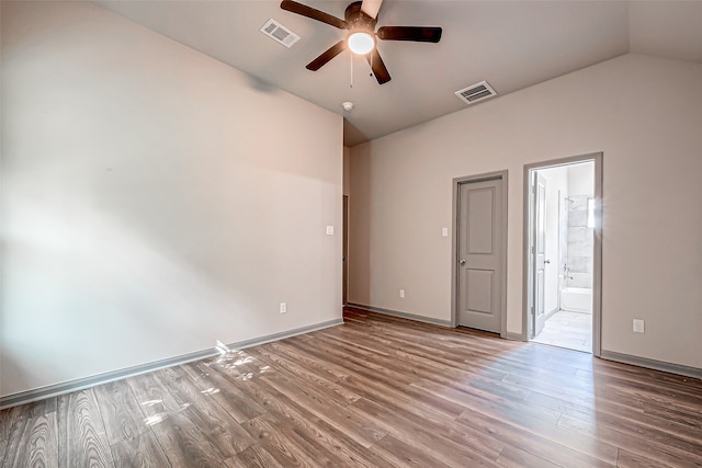 empty room featuring wood-type flooring, vaulted ceiling, and ceiling fan