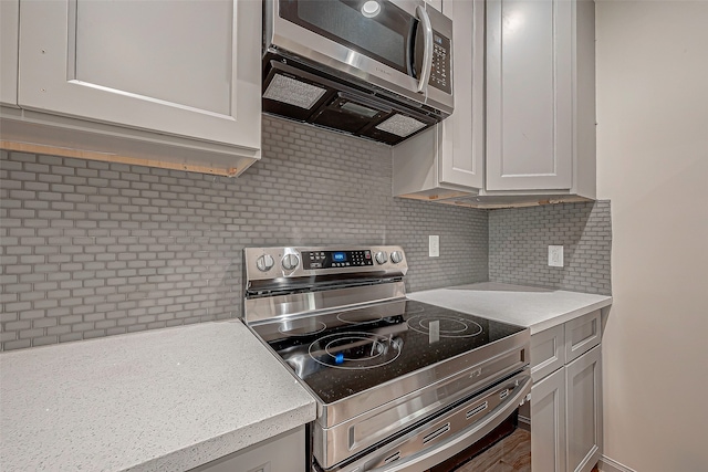 kitchen featuring appliances with stainless steel finishes, decorative backsplash, and wood-type flooring