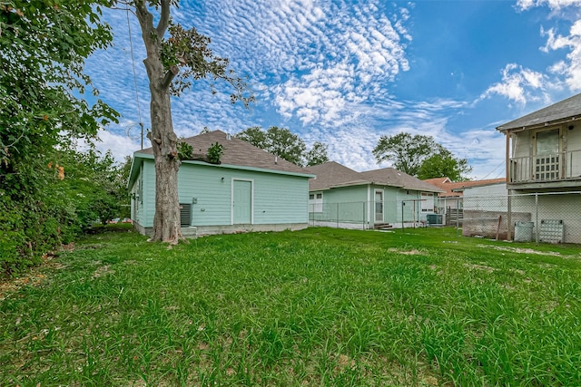 back of property featuring a lawn and central AC