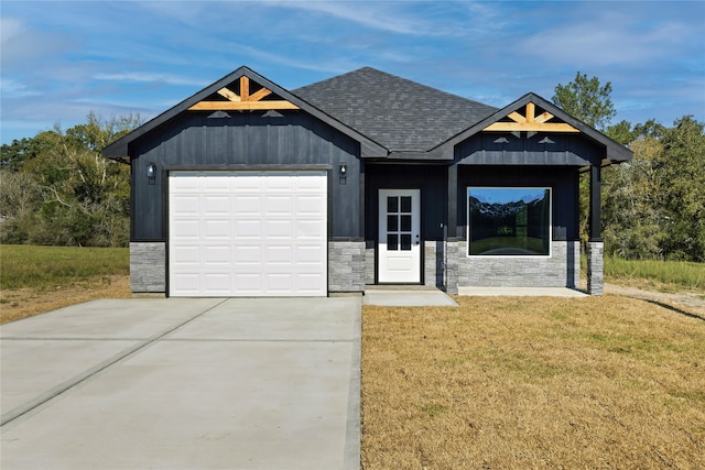 view of front of property featuring a front yard and a garage