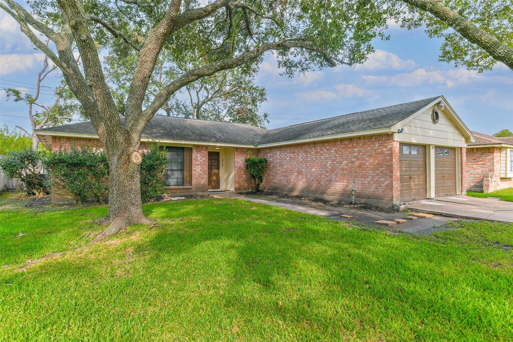 ranch-style home with a garage and a front lawn