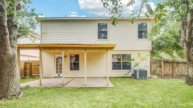 back of property with central AC unit, a yard, and a patio area