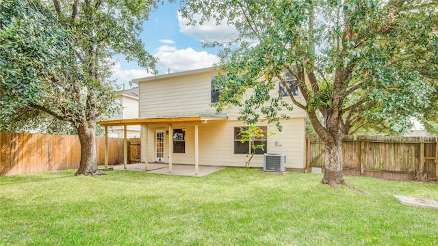 back of property with a lawn, cooling unit, and a patio area