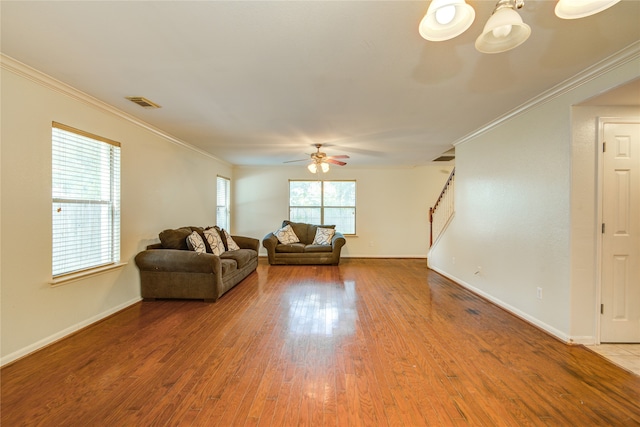 unfurnished living room featuring ceiling fan with notable chandelier, ornamental molding, and wood-type flooring