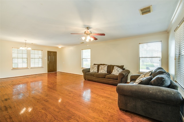 living room featuring ceiling fan with notable chandelier, light wood-type flooring, and crown molding