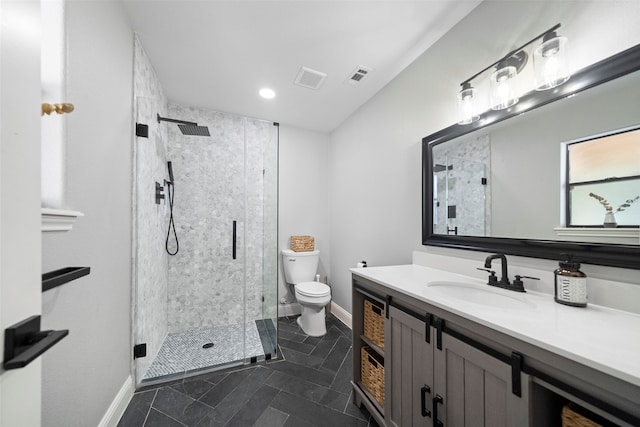 bathroom featuring tile patterned floors, vanity, toilet, and a shower with shower door