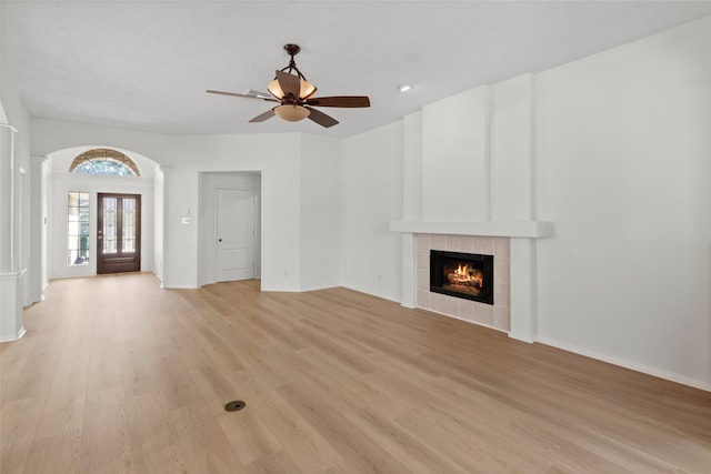 unfurnished living room featuring light wood-style flooring, a fireplace, and ceiling fan