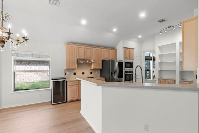 kitchen featuring wine cooler, under cabinet range hood, stainless steel appliances, visible vents, and light brown cabinetry