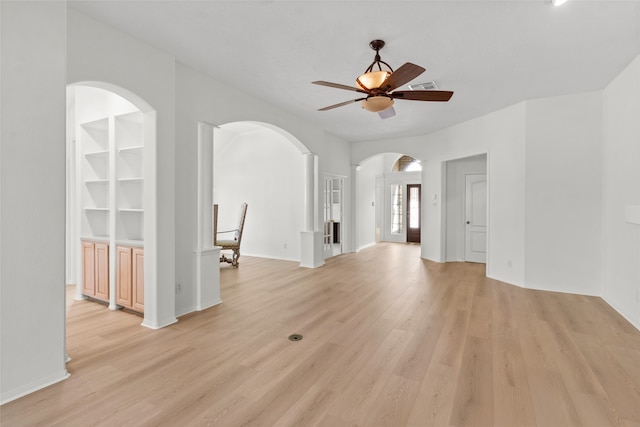 unfurnished living room with ceiling fan, arched walkways, visible vents, built in features, and light wood-style floors