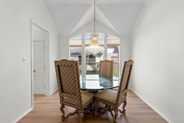 dining space with vaulted ceiling, baseboards, light wood-style flooring, and a notable chandelier