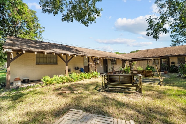 rear view of house featuring a yard