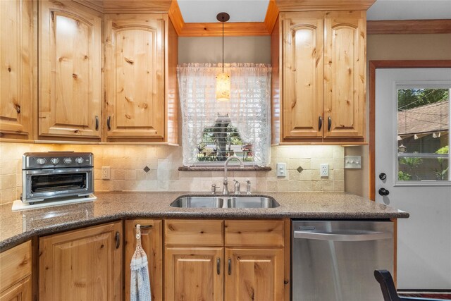 kitchen with decorative backsplash, dishwasher, hanging light fixtures, and sink