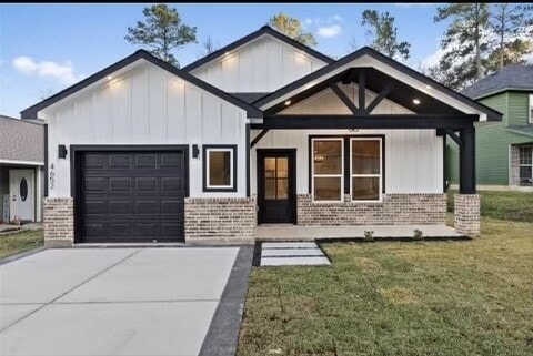 view of front of home featuring a porch, a garage, and a front lawn