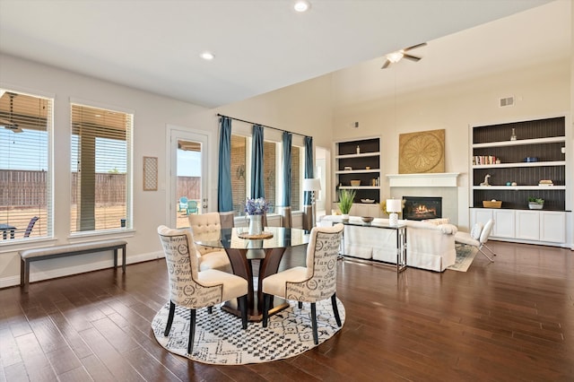 dining space featuring a healthy amount of sunlight, built in shelves, and dark wood-type flooring