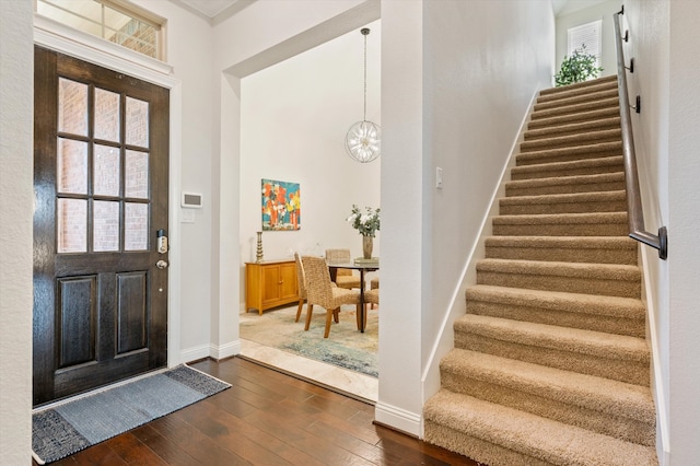 foyer featuring dark hardwood / wood-style floors and a chandelier