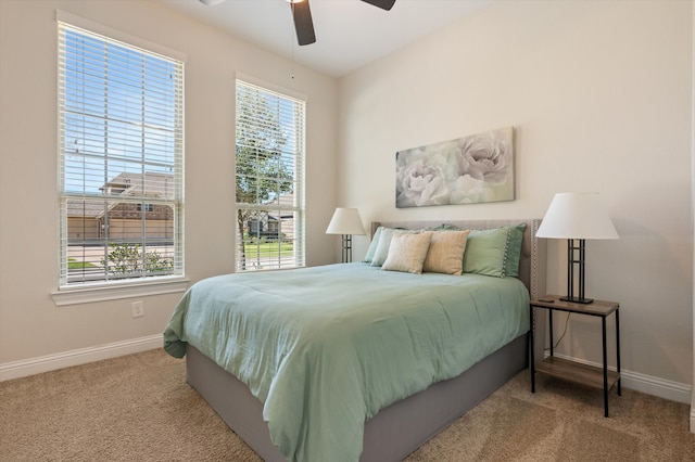 carpeted bedroom featuring ceiling fan and multiple windows