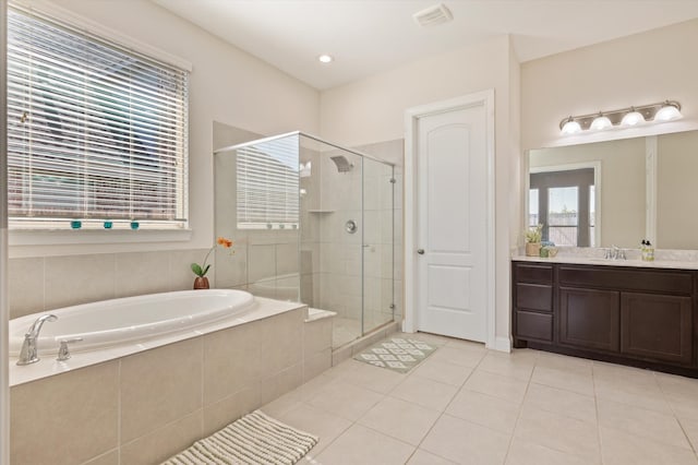 bathroom featuring independent shower and bath, vanity, tile patterned floors, and a wealth of natural light