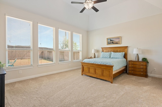 bedroom featuring light carpet, lofted ceiling, multiple windows, and ceiling fan