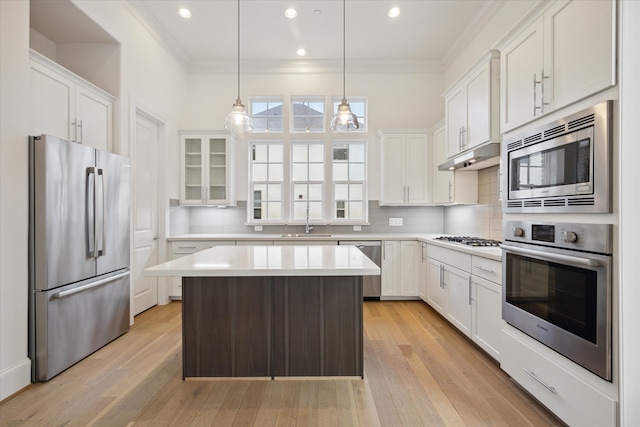 kitchen featuring light hardwood / wood-style flooring, a kitchen island, stainless steel appliances, and white cabinetry