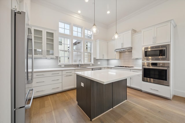 kitchen featuring white cabinets, a kitchen island, stainless steel appliances, light hardwood / wood-style flooring, and sink