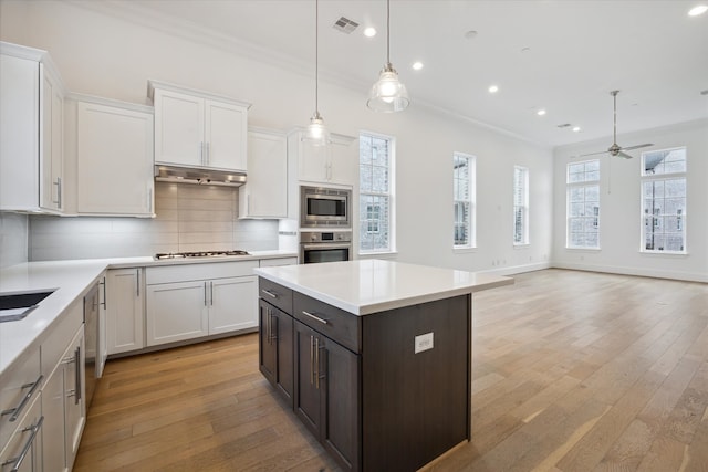 kitchen featuring light hardwood / wood-style flooring, decorative backsplash, ceiling fan, and plenty of natural light