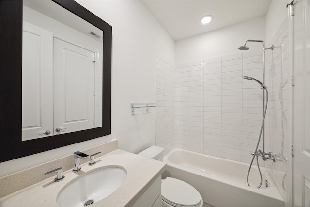 full bathroom with vanity, tiled shower / bath combo, and toilet