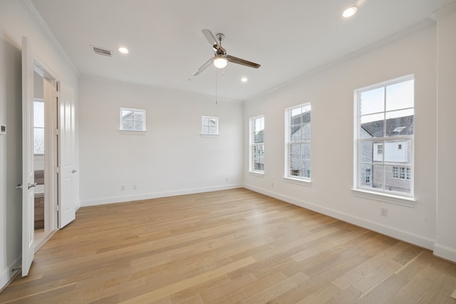 unfurnished room featuring ceiling fan, light hardwood / wood-style flooring, crown molding, and a wealth of natural light