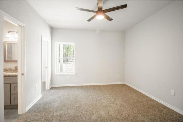 unfurnished bedroom with ceiling fan, carpet flooring, and connected bathroom