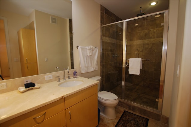 bathroom featuring vanity, toilet, an enclosed shower, and tile patterned floors