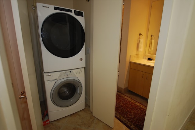 washroom featuring stacked washer / drying machine and light tile patterned floors