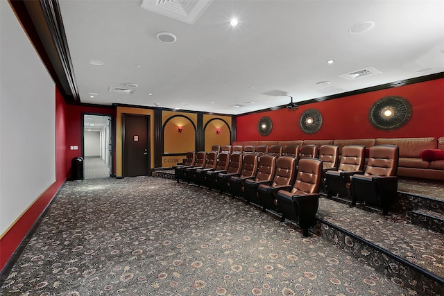 carpeted home theater room featuring crown molding