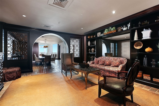 sitting room with carpet flooring, a chandelier, and ornamental molding