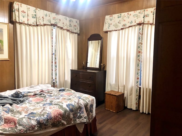 bedroom featuring wood walls and dark hardwood / wood-style floors