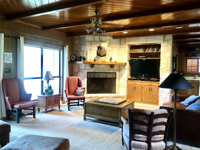 living room with wood ceiling, a fireplace, beam ceiling, and ceiling fan