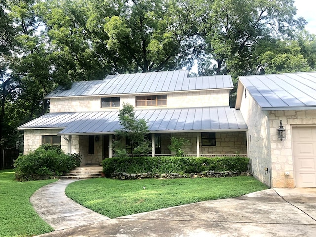 view of front of property with a garage, a porch, and a front lawn