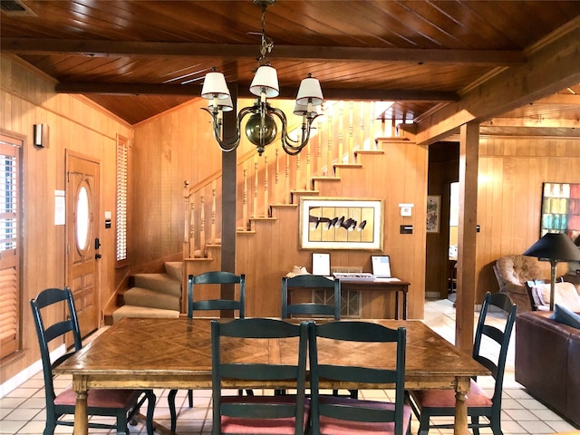 tiled dining space featuring a notable chandelier, wood walls, beam ceiling, and wooden ceiling