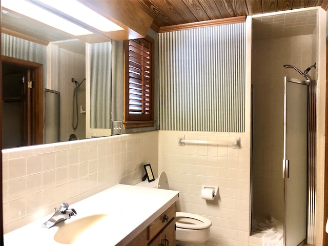 bathroom featuring walk in shower, vanity, tile walls, and toilet