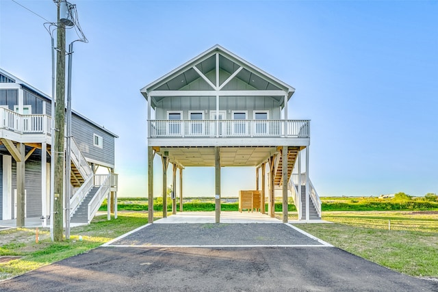 raised beach house featuring a front lawn