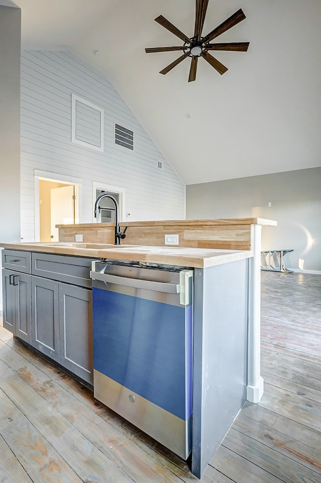 kitchen with high vaulted ceiling, dishwasher, gray cabinets, ceiling fan, and light hardwood / wood-style flooring