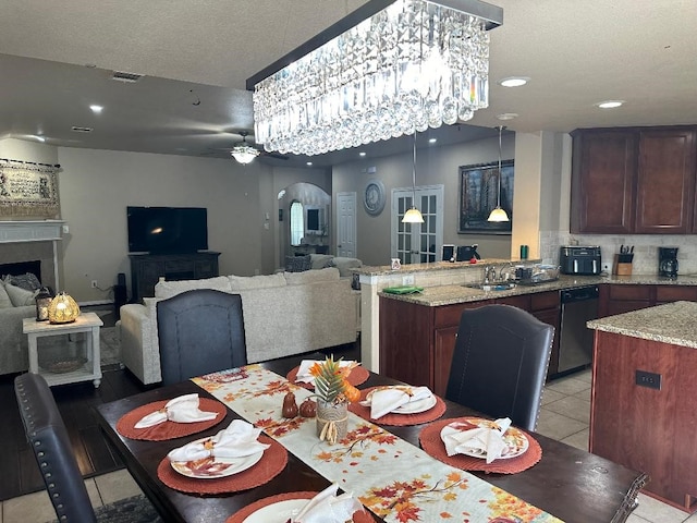 tiled dining room with a textured ceiling and ceiling fan