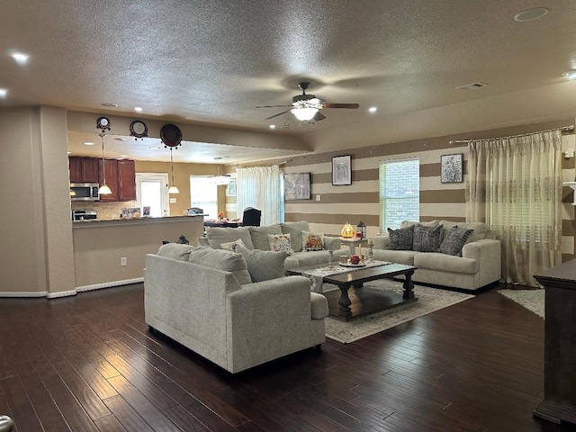 living room featuring ceiling fan, a textured ceiling, and plenty of natural light