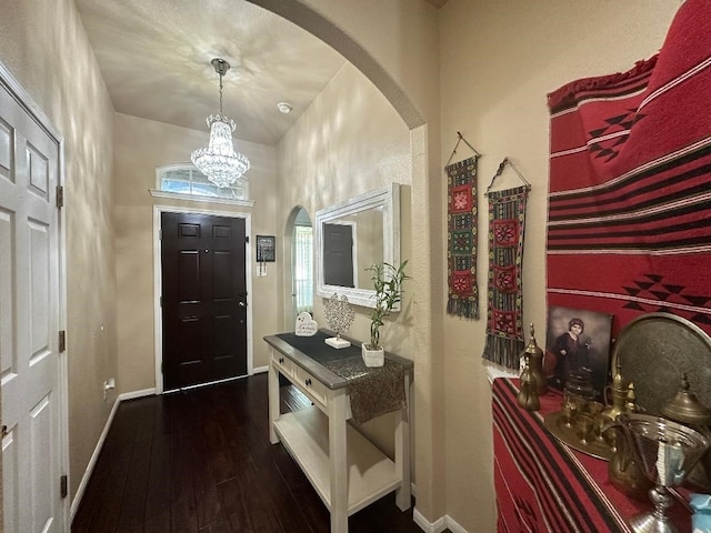 foyer entrance with a chandelier and dark hardwood / wood-style flooring