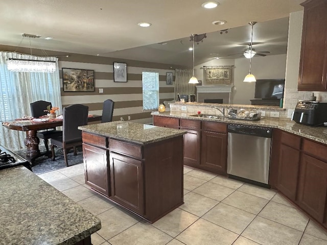 kitchen featuring ceiling fan, hanging light fixtures, a center island, and stainless steel dishwasher