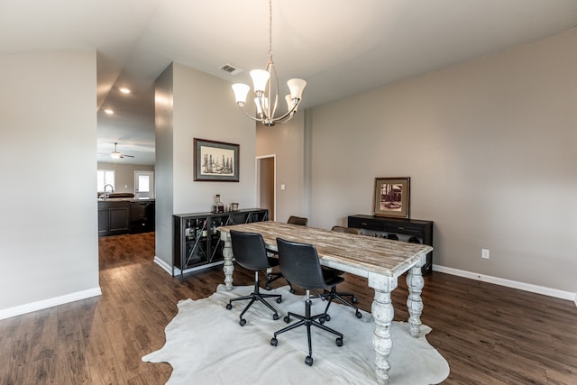 home office with ceiling fan with notable chandelier, sink, and dark wood-type flooring