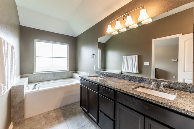 bathroom with tile patterned flooring, vanity, lofted ceiling, and a bathtub