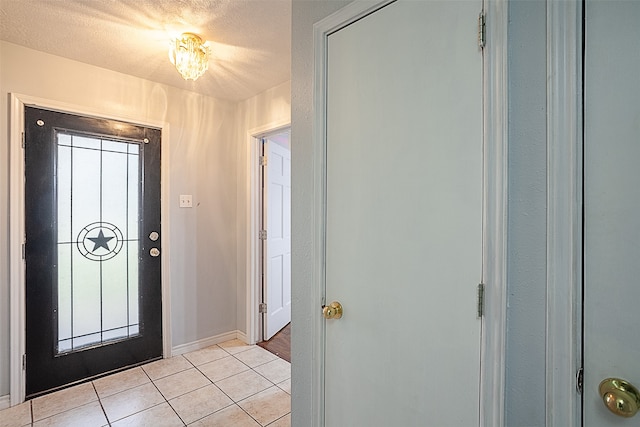 tiled entrance foyer featuring a textured ceiling