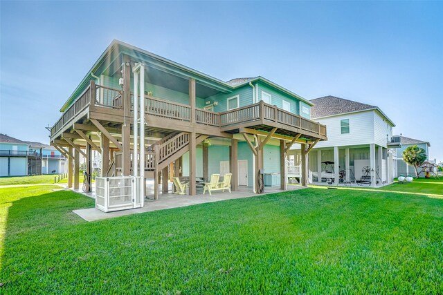 rear view of property featuring a deck, a yard, and a patio area